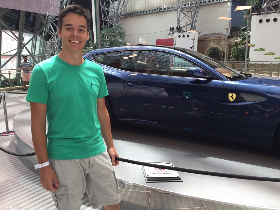 Fernando posando para foto em frente a uma Ferrari azul